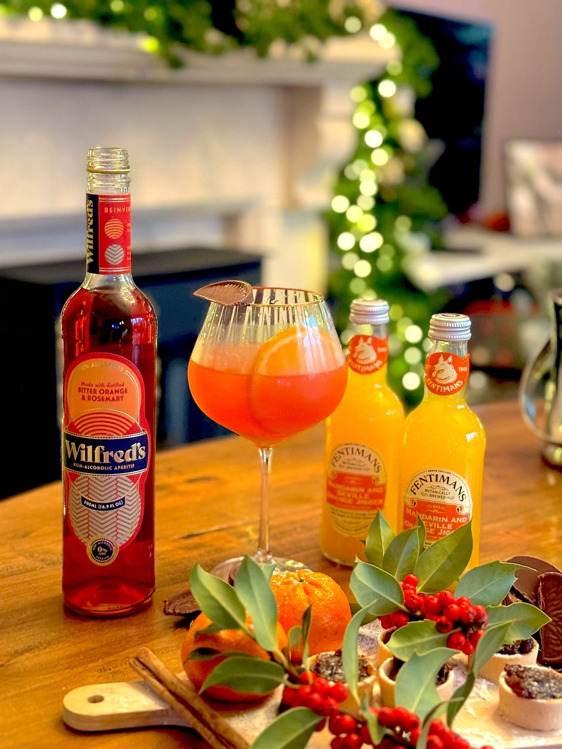 Wilfred's Chocolate Orange Spritz on a festive table with two bottles of Fentimans Mandarin & Seville Orange Jigger